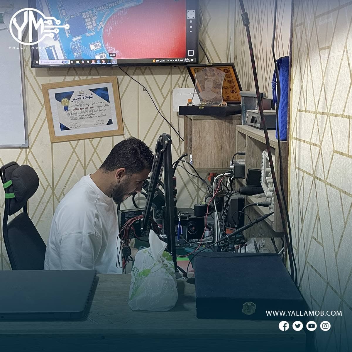 متدرب يعمل تحت الميكروسكوب على إصلاح بورد إلكتروني حقيقي